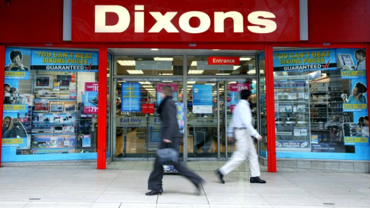 Pedestrians walk past a Dixons electrical retail shop in London