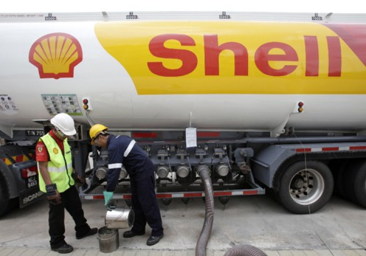 Workers prepare to pump petrol at a Shell station