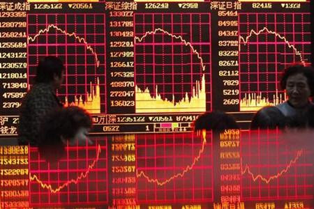 People look at an electronic board at a brokerage house in Shanghai
