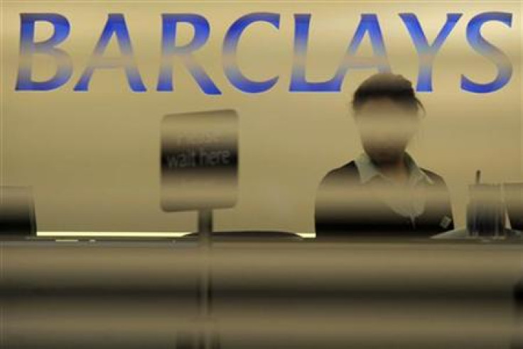 A worker waits for customers in a branch of Barclays bank in London