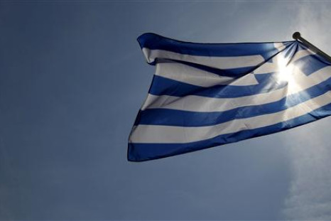 A Greek flag flies in the wind at a park in central Athens