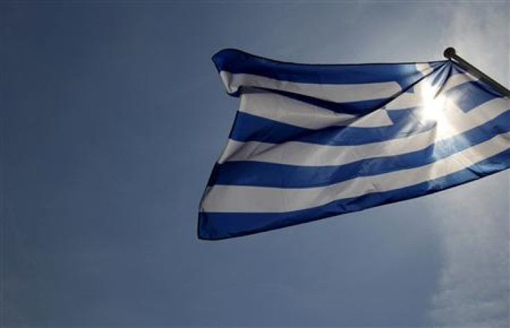 A Greek flag flies in the wind at a park in central Athens