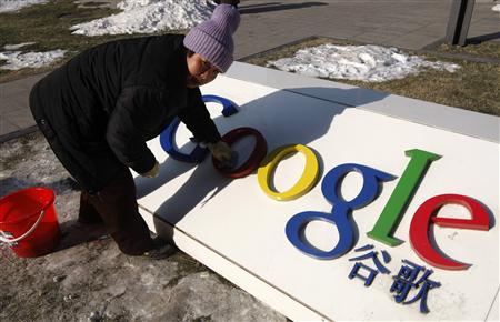 A woman cleans the logo of Google China outside the company headquarters in Beijing