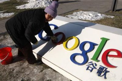 A woman cleans the logo of Google China outside the company headquarters in Beijing