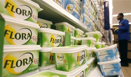 A worker scans barcodes by a chiller cabinet of Flora margarine at a Sainsbury's supermarket in London