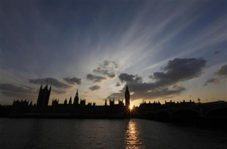 The sun sets behind the Palace of Westminster, in London