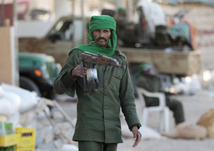 A Libyan soldier loyal to leader Muammar Gaddafi stands in a street strewn with rubble in the city of Misrata, 200 km (124 miles) east of the capital Tripoli March 28,2011.