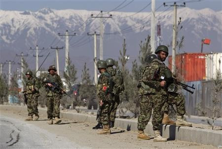 An Afghan National Army soldiers keeps watch after an attack at Camp Phoenix