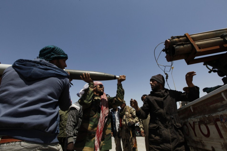 Rebels load a weapon on the road to the frontline in Brega