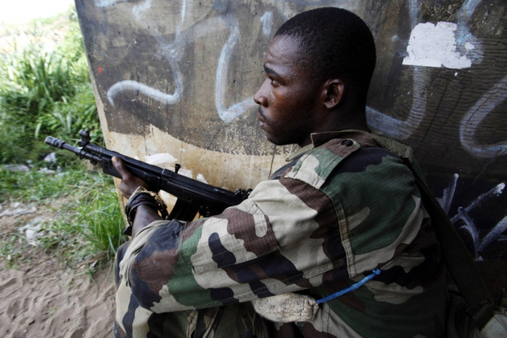 A soldier loyal to Ivory Coast presidential claimant Ouattara holds position along road in Abidjan