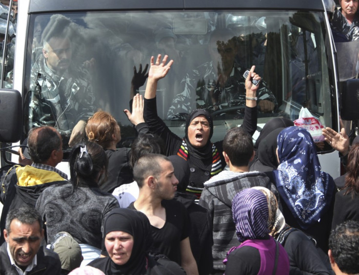 Relatives of inmates in Roumieh prison block the road in front of a policemen bus during a protest near the prison, east of Beirut