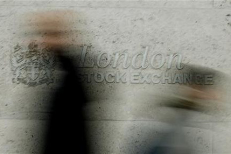 Pedestrians walk past the London Stock Exchange in the City of London