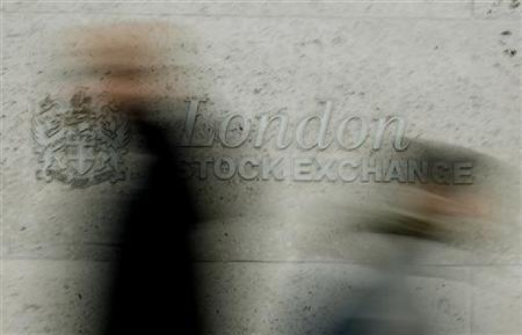 Pedestrians walk past the London Stock Exchange in the City of London