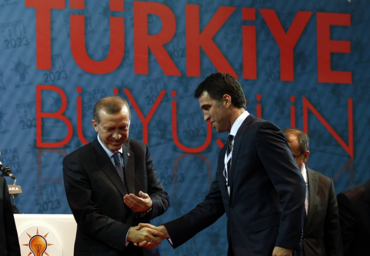 Turkey's PM Erdogan shakes hands with Istanbul candidate Hakan Sukur