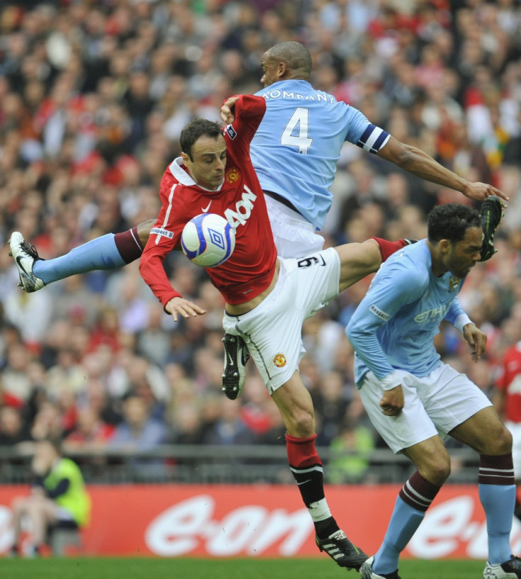 Manchester City's Vincent Kompany and Joleon Lescott challenge Manchester United's Dimitar Berbatov for the ball during their FA Cup semi-final soccer match in London