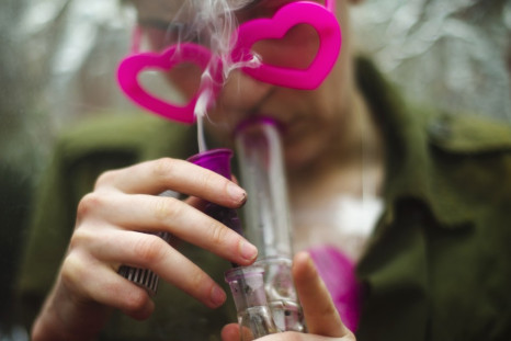 A woman smokes marijuana from a bong before The Global Marijuana March in Toronto