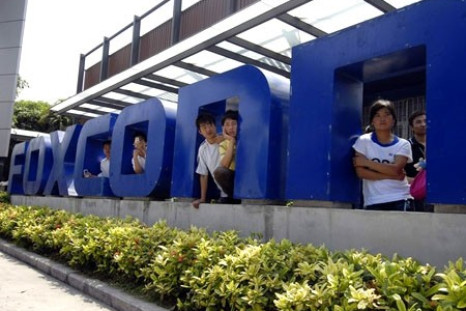 Workers stand at the gate of a Foxconn factory in the township of Longhua in Shenzhen, Guangdong province May 26, 2010