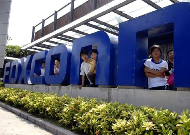 Workers stand at the gate of a Foxconn factory in the township of Longhua in Shenzhen, Guangdong province May 26, 2010