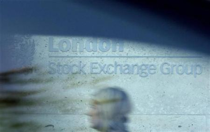 A woman is seen through a car window as she walks past the London Stock Exchange
