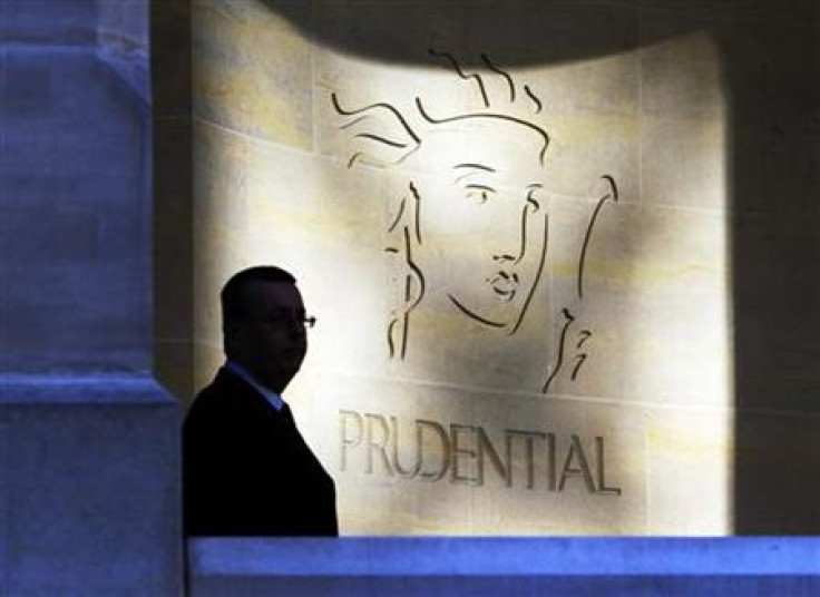 A security guard is silhouetted in front a Prudential office in London