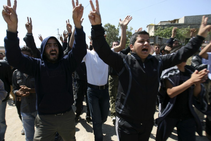 Syrian men chant slogans against their President Bashar al-Assad after arriving in Wadi Khaled in northern Lebanon