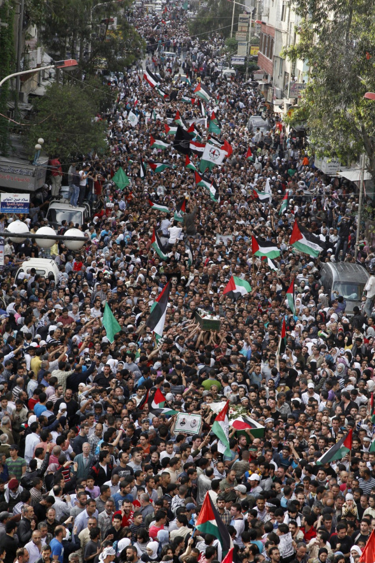 Palestinians carry the coffins of people, who were shot dead  by Israeli soldiers during clashes at Majdal Shams, during a funeral in al-Yarmouk camp near Damascus